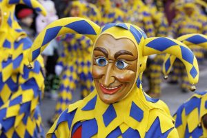 blau-gelb gekleideter Narr mit Narrenkappe