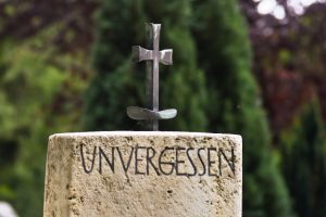 Grabstein mit Kreuz und Inschrift "Unvergessen"